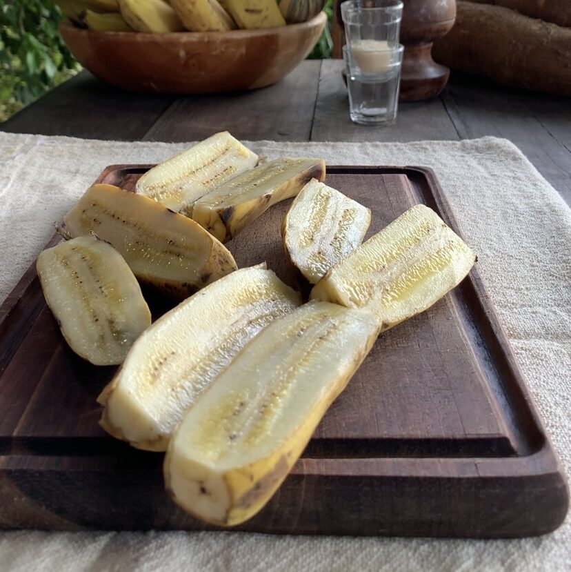 Banana partida ao meio sobre uma taboa de madeira
