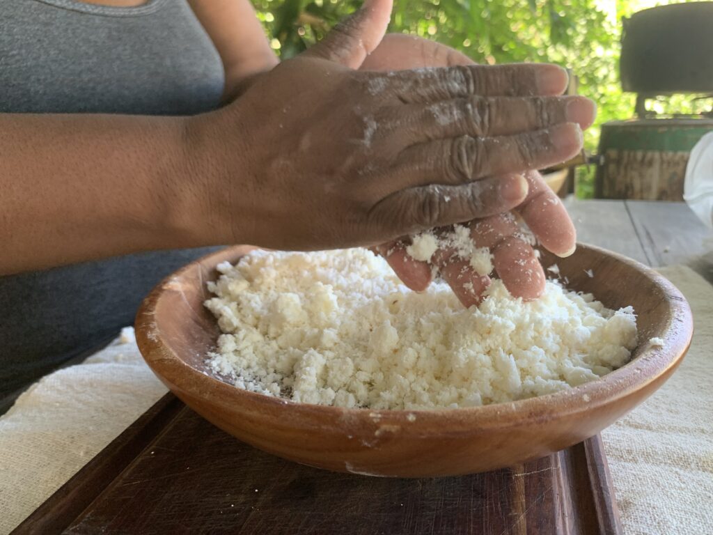 Mãos misturando massa de mandioca mansa